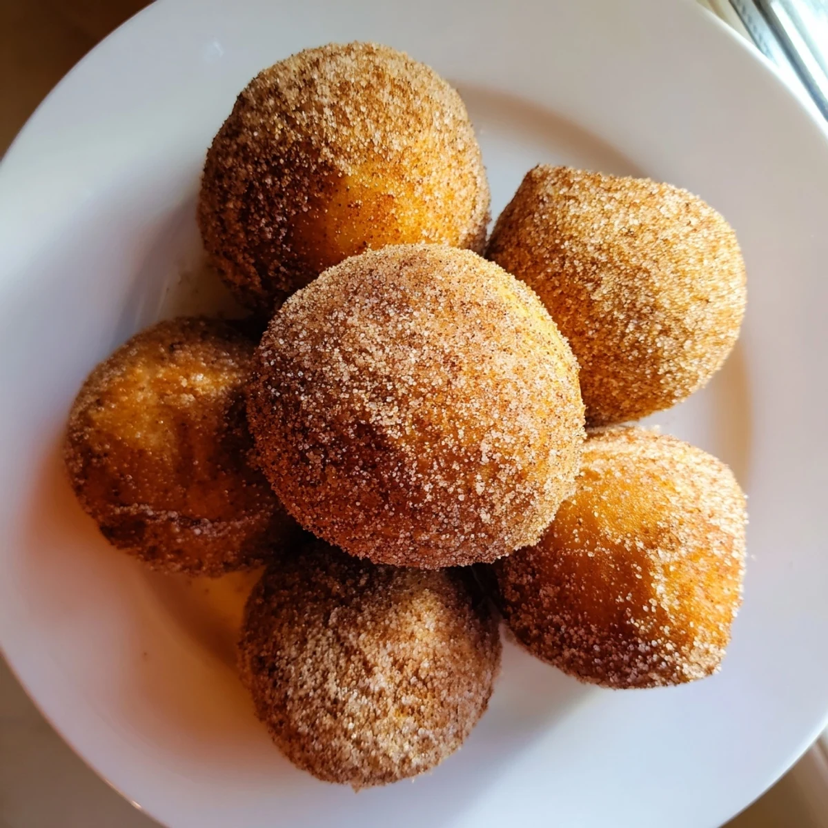 These air fryer cinnamon donuts are lightly brushed with butter and covered in a cinnamon sugar coating.