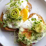 Breakfast scene: Warm cloud toast 2.0 with a perfectly cooked yolk and vibrant microgreens garnish.