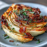 Hearty roasted cabbage steaks glistening with olive oil and garlic, ready to serve.