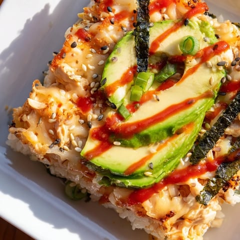 Golden bubbly chicken sushi bake with creamy topping, ready to serve with nori sheets.