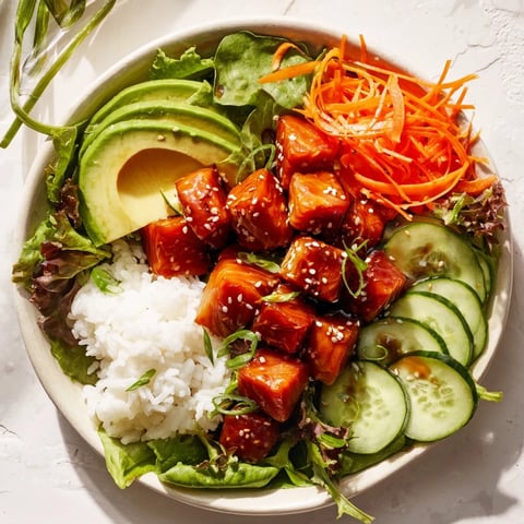 Fresh, glistening Poke Bowl Salad with vibrant greens, marinated fish, and sesame seed garnish.