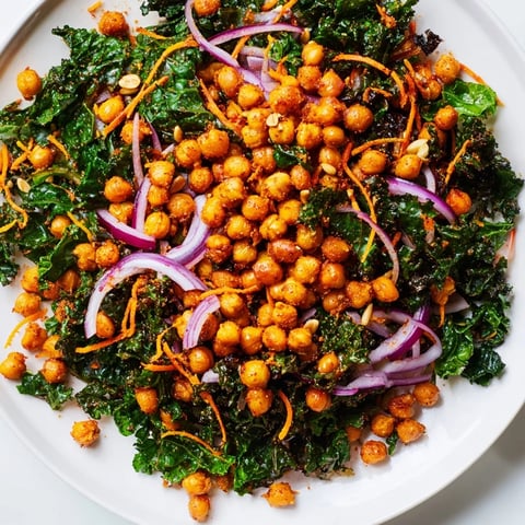 Golden roasted chickpeas top a fresh and colorful kale salad, perfect for a quick lunch.
