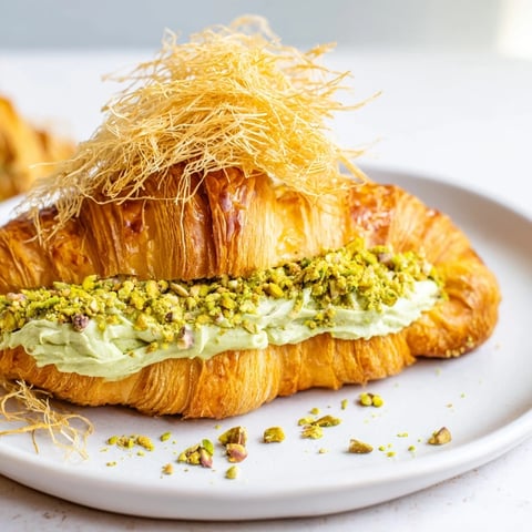 Flaky, golden Pistachio Cream Croissants, a luxurious pastry filled with vibrant green pistachio cream.