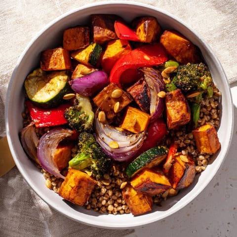 A vibrant close-up shows a healthy Hearty Roasted Vegetable and Farro Bowl, perfect for a satisfying meal.