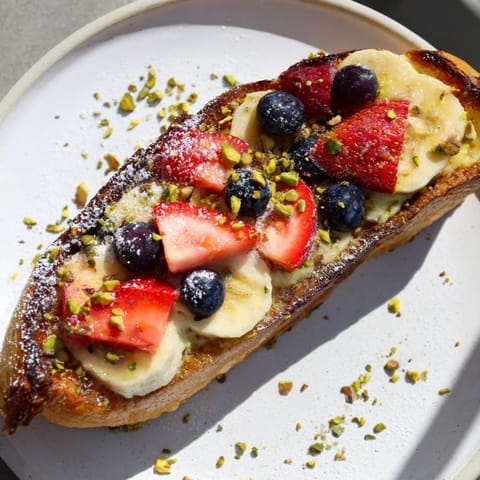 Baked Viral Yogurt Toast, topped with colorful sliced fruit, smells amazing fresh out of the oven.