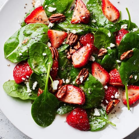 A closeup reveals components of the Spinach Strawberry Salad with a sweet poppy seed dressing.