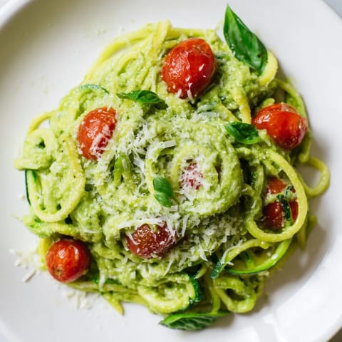 Avocado Pesto Zoodles served in a white bowl, garnished with extra basil, ready to eat as a light low-carb vegetarian main dish.