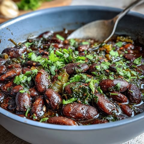 Hearty soul food black-eyed pea and collard green stew with smoky, earthy flavors in a comforting Southern bowl.