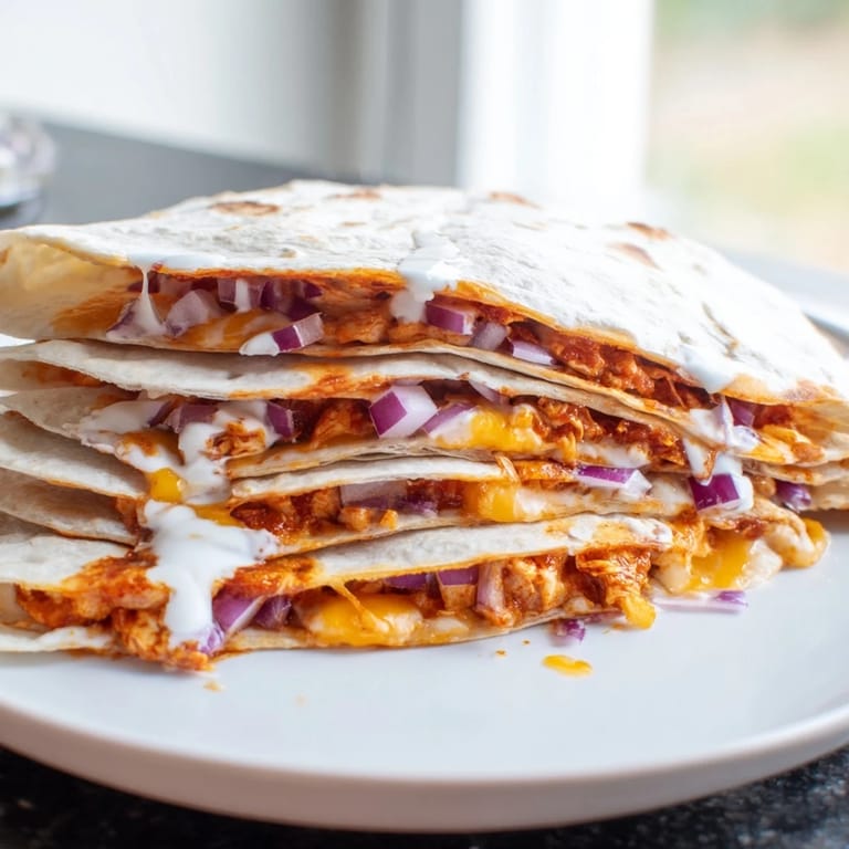 Freshly cut Buffalo Chicken Quesadilla, a taste of melted cheese with a spicy, flavorful chicken filling.