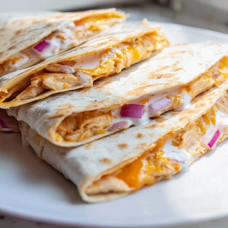 A close-up of a delicious Buffalo Chicken Quesadilla, filled with chicken and vegetables, warm and savory.