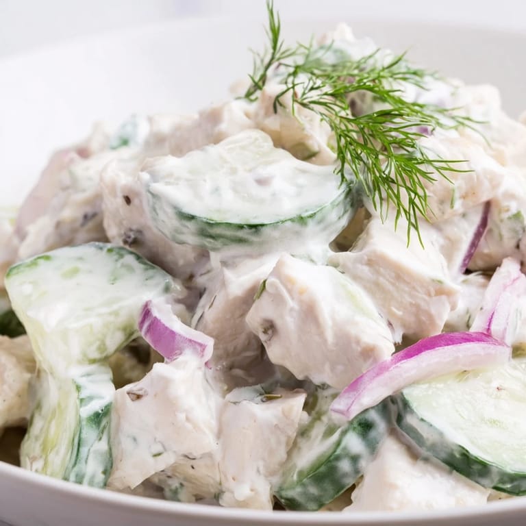 In a wooden bowl, Creamy Cucumber Chicken Salad features tender chicken and crunchy cucumbers tossed in a creamy Greek yogurt dill dressing.