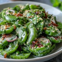 Vibrant Snap Pea and Radish Spring Salad with creamy tahini dressing, ready to serve.